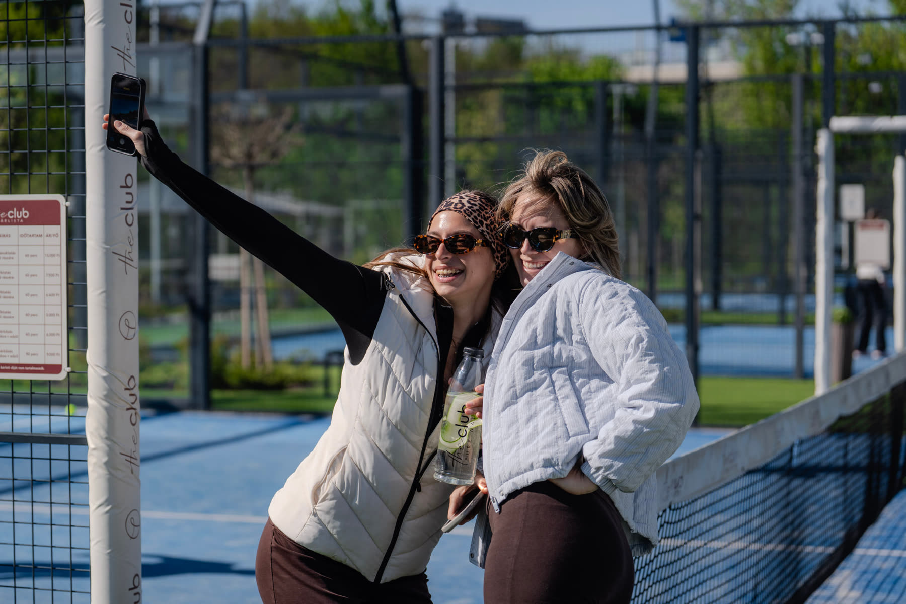 Guests taking a selfie by the padel net
