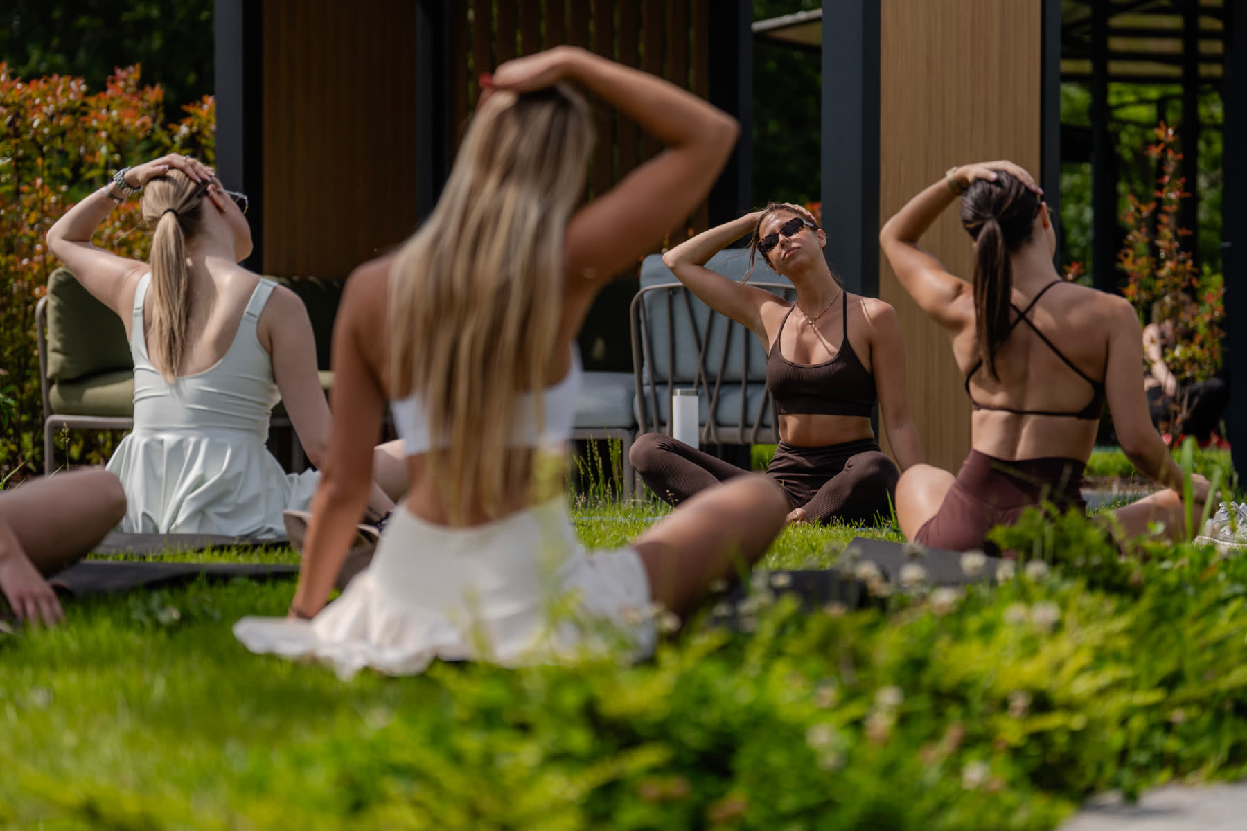 Guests stretching and relaxing on the lawn after padel